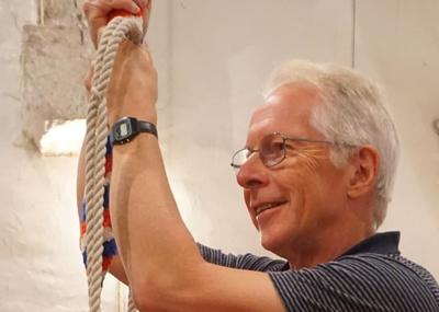 A man holding a bell rope